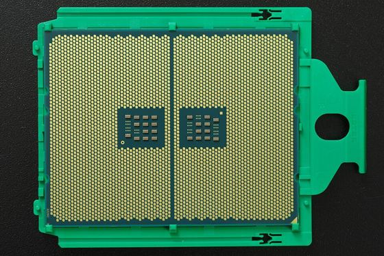 Bottom side of an AMD EPYC server processor in its carrier frame, showing thousands of gold contact pads